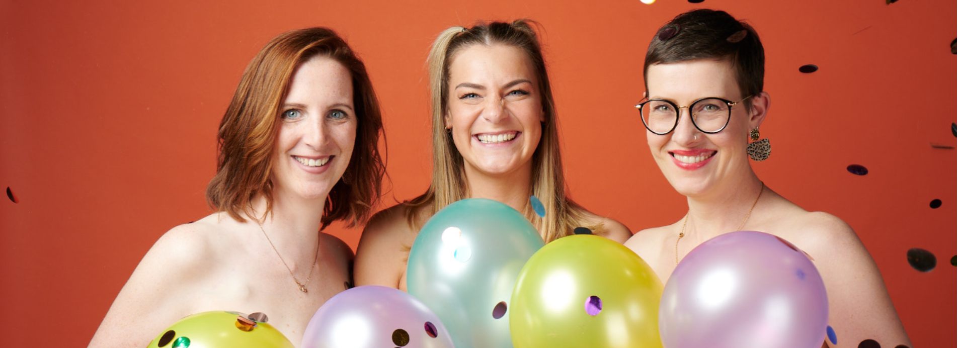 Drei Frauen aus dem Buusenkollektiv halen Luftballons hoch und im Hintergrund ist Konfetti.